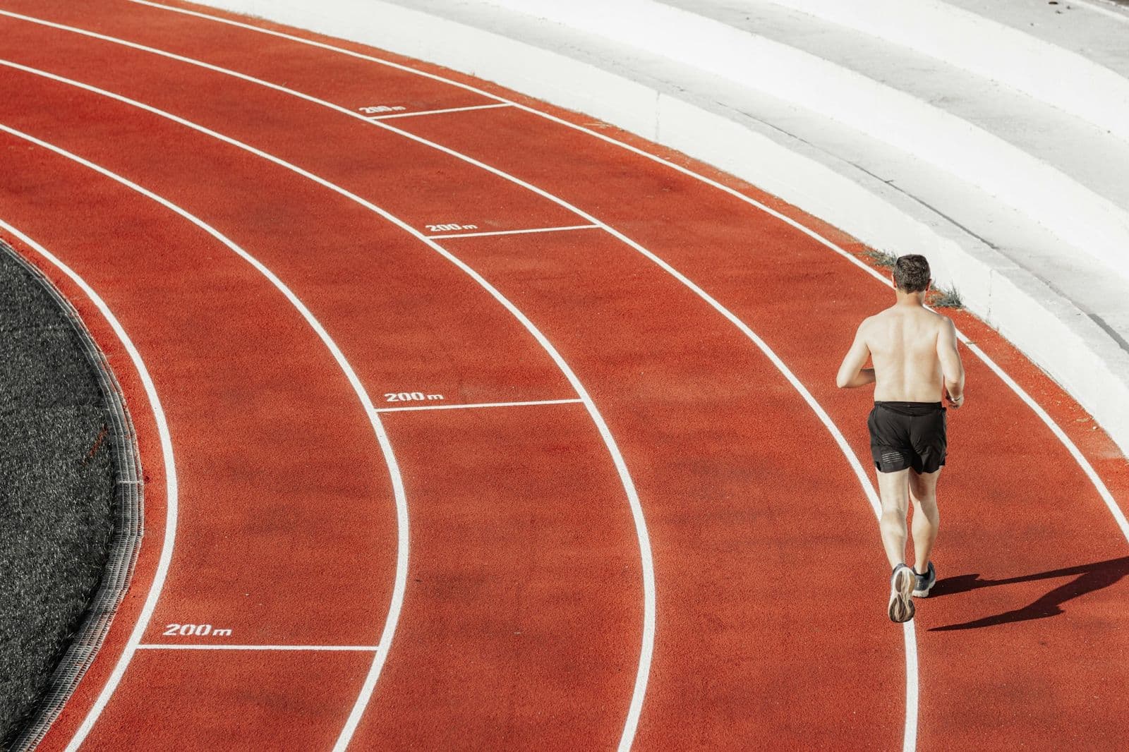A runner on the bend of a red running track