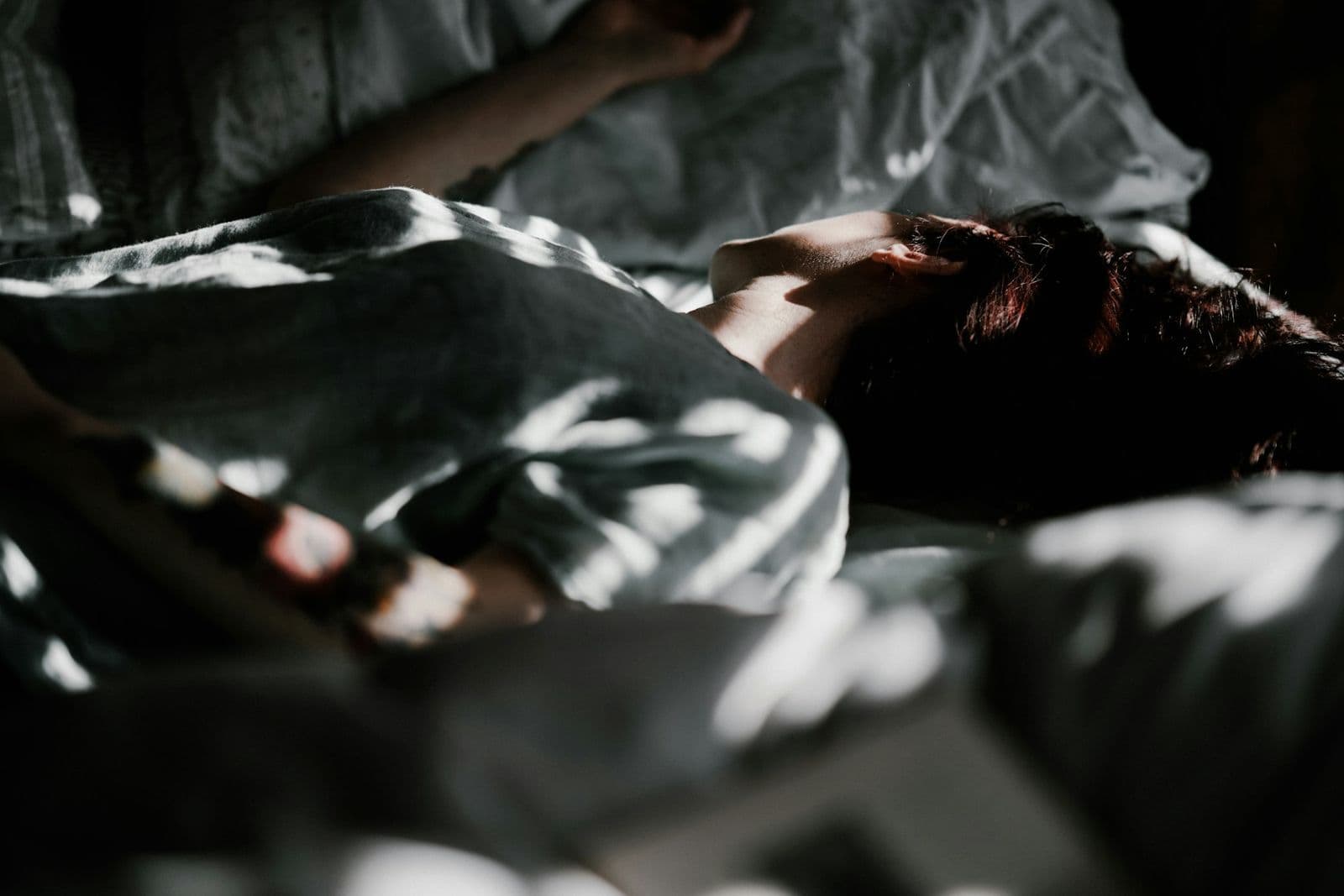 Someone asleep under a blanket in soft morning light